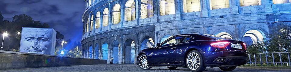 Car parked outside of the Colosseum in Rome at night